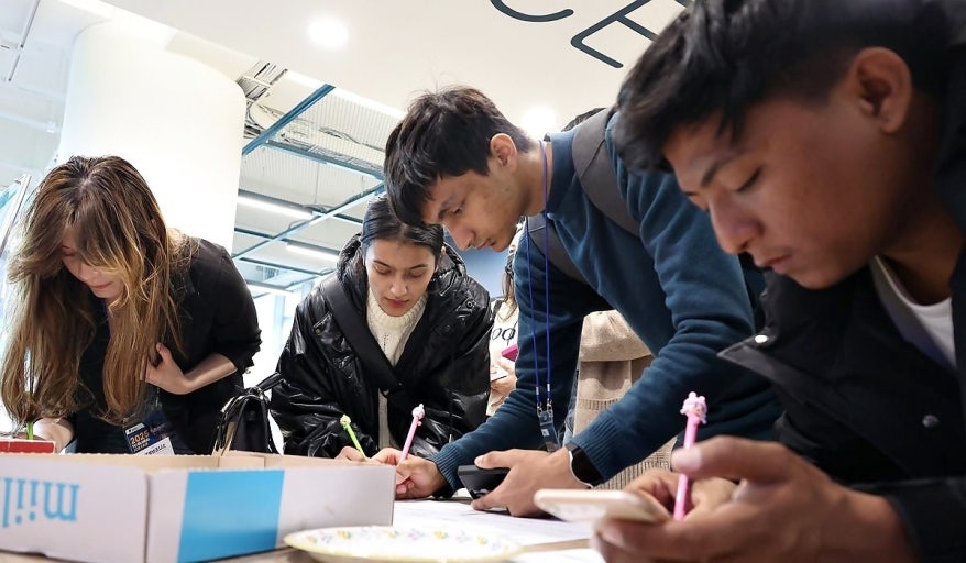 Các sinh viên quốc tế đang điền tờ khai làm thủ tục xin visa du học Hàn Quốc tại trung tâm tiếp nhận thị thực